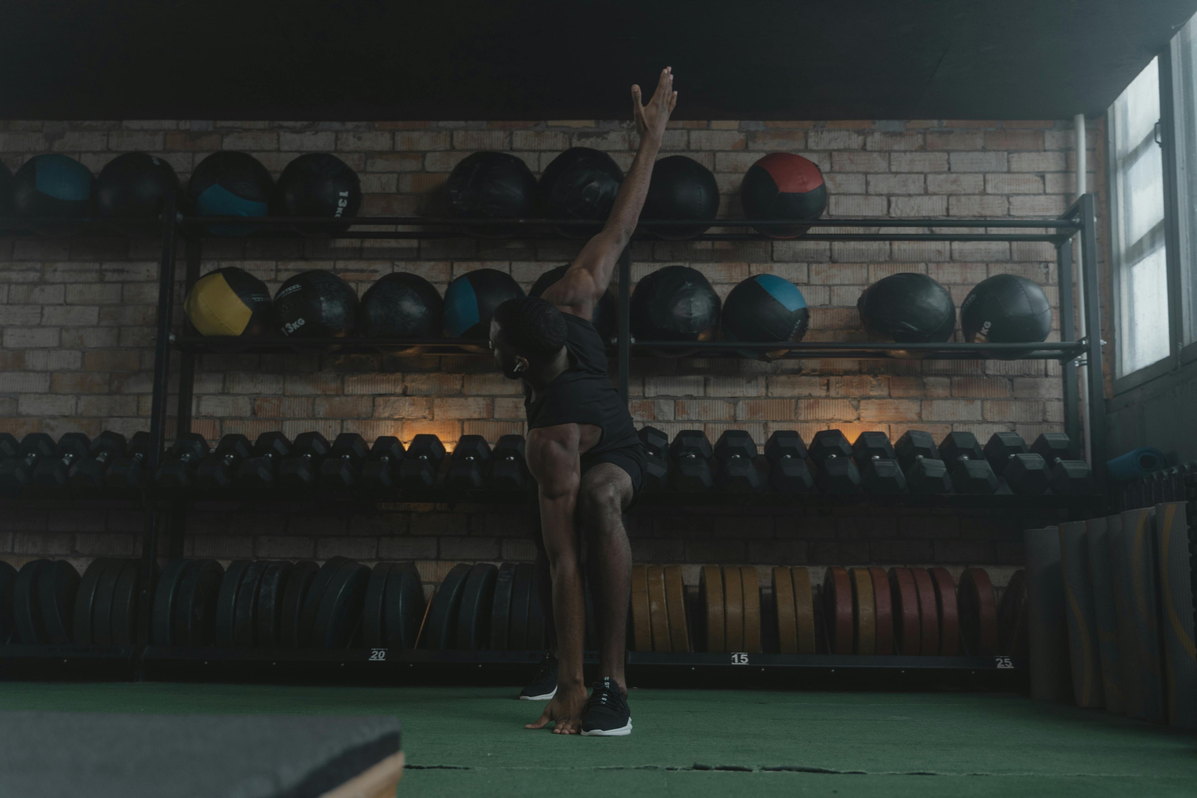 Person exercising with medicine balls in a gym setting